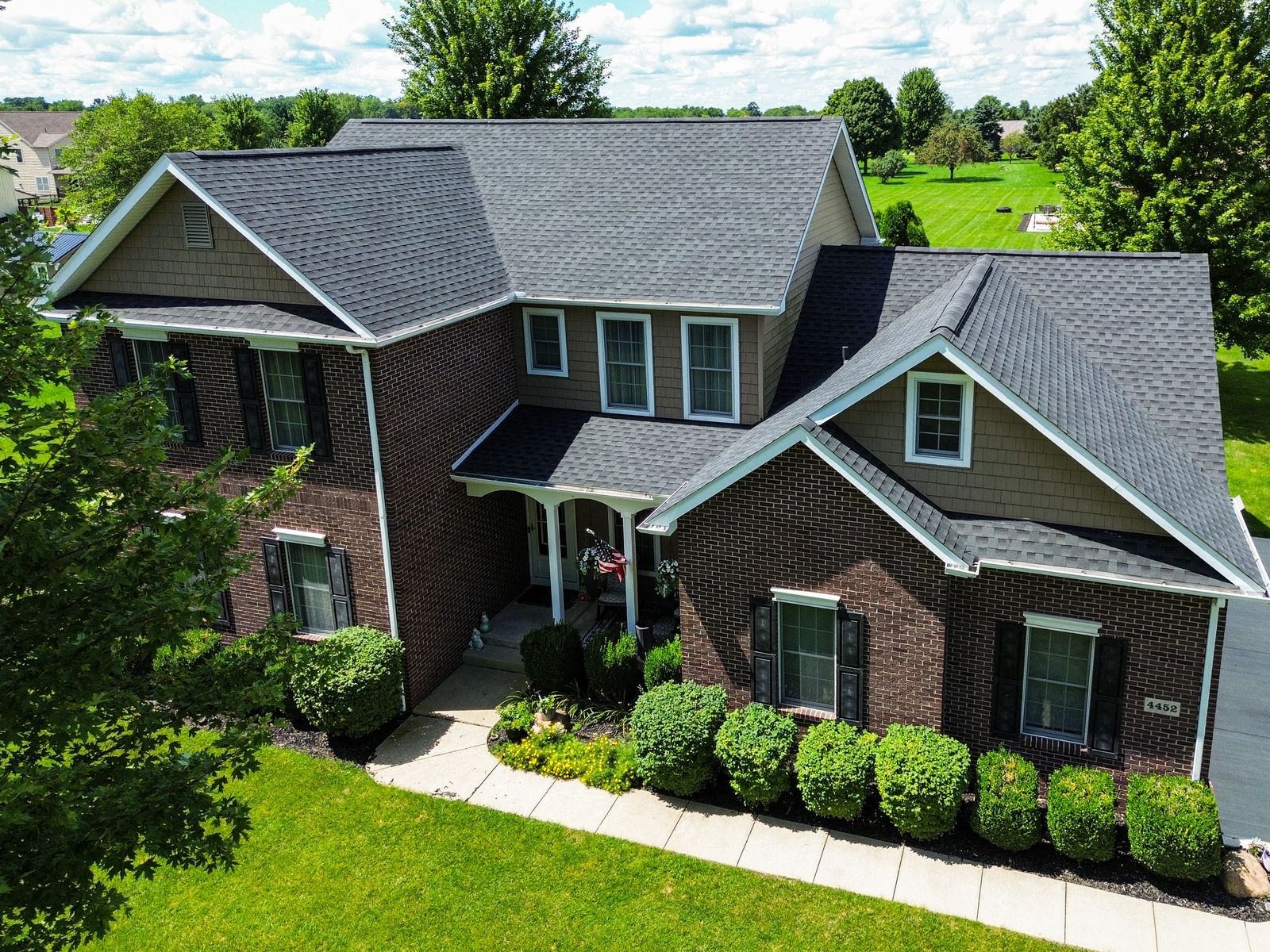 Completed GAF Timberline HDZ Charcoal roof on a two-story brick and cedar-shake home — Bellefontaine, Ohio