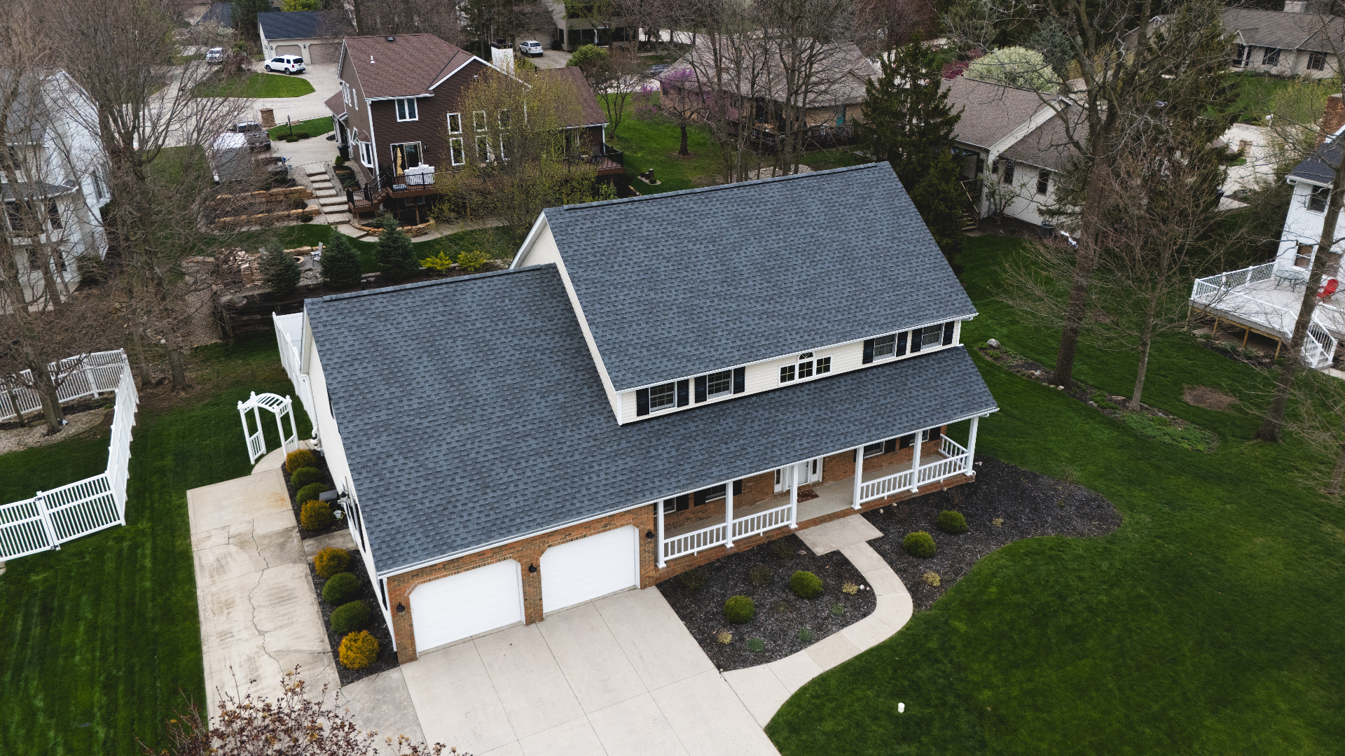 Aerial view of completed Pewter Gray GAF Timberline HDZ shingle roof on a two-story brick colonial — Whispering Pines, Bellefontaine, Ohio GAF certified referral roof replacement by Peak One Restorations